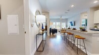 Located at 1701 Rinehart Rd in Sanford, FL, this thoughtfully designed 2-bedroom, 2-bathroom single-story residence offers a comfortable and modern living experience. Wood-style plank flooring runs throughout, lending warmth and cohesion to every room.

The entry hallway welcomes you with a stylish console and flows seamlessly into the open-concept living area. The living room is bright and airy, featuring large windows and a glass-paneled door that fill the space with natural light and provide outdoor views. A ceiling fan adds to the comfort of the room.

The kitchen is a standout, boasting white shaker cabinetry, granite countertops, a subway tile backsplash, stainless steel appliances, and a breakfast bar with barstool seating — ideal for casual dining or entertaining.

The primary bedroom is generously sized, offering multiple windows with natural light, and is complemented by a dedicated walk-in closet with wire shelving. The second bedroom is equally comfortable with ample space. Both bathrooms feature granite-topped vanities, white cabinetry, and large mirrors.

A dedicated laundry room with a full-size washer and dryer adds everyday convenience. With two closets and a practical hallway connecting all spaces, this residence delivers an efficient and polished floor plan throughout.