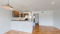 This 550 square foot apartment in Houston, TX offers a well-designed living space on a single floor. The layout includes one bedroom measuring 150 square feet, one bathroom, and an open-concept kitchen and living area. The interior is characterized by its bright and airy ambiance, enhanced by large windows that allow ample natural light to flood the space.

Throughout the apartment, warm-toned hardwood flooring creates a cohesive and inviting atmosphere. The kitchen features modern appliances, including a stainless steel refrigerator and gas range. Ample cabinetry in a neutral tone provides storage and complements the overall design. A peninsula countertop doubles as a breakfast bar, separating the kitchen from the living area while maintaining an open feel.

The bedroom is spacious and well-lit, with a large window and a ceiling fan for comfort. It includes a closet for storage. The bathroom, while compact, is efficiently designed with a combination tub-shower, toilet, and vanity. The apartment also includes additional closet space in the hallway.

Notable features include ceiling fans in the main living areas, recessed lighting, and large windows that offer views of the surrounding neighborhood. The neutral color palette of white walls and warm wood tones creates a blank canvas for personal decorating styles. This apartment combines modern amenities with a practical layout, making efficient use of its compact square footage.