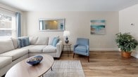 This two-floor residence offers a thoughtfully designed layout with a cohesive coastal-inspired aesthetic throughout. The galley-style kitchen is well-equipped, featuring white shaker cabinetry, granite countertops, black stainless appliances including a range and over-the-range microwave, a double basin sink, and wood-look flooring underfoot. A striped area rug adds a nautical touch to the space.

The living room is comfortably sized, with wood-look flooring, neutral walls, and windows that invite natural light. It flows naturally into a dedicated dining area, which is highlighted by a pendant light fixture and a large sliding glass door offering outdoor views and additional brightness.

The bedrooms are generously proportioned, each featuring plush carpeting, neutral wall tones, and windows that provide natural light and a sense of openness. The primary bedroom offers ample space for a full furniture arrangement.

Two bathrooms serve the residence. One features tile flooring, a tub-shower combination, and a warm wood vanity with a light countertop. The second bathroom includes wood-look flooring, a granite-topped vanity with white cabinetry, and framed mirror — both finished in a clean, updated style throughout.