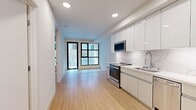 Located at 1641 Lincoln Blvd, Unit 1-207 in Santa Monica, CA, this thoughtfully designed one-bedroom, one-bathroom apartment offers 430 square feet of modern living space. The open-concept layout maximizes functionality throughout the single-floor unit.

The kitchen is a standout feature, boasting high-gloss white cabinetry extending to the ceiling, a marble-veined quartz countertop and backsplash, and a full suite of stainless steel appliances including a refrigerator, dishwasher, over-the-range microwave, and oven/range. Recessed lighting illuminates the space, complemented by light bamboo hardwood flooring that flows throughout the unit.

The 130 square foot bedroom features a ceiling fan, a large black-framed grid window that brings in natural light, and double doors providing ample closet space. The in-unit stacked washer and dryer adds everyday convenience.

The bathroom is finished with crisp white large-format wall tiles, a full soaking tub with shower combo, brushed nickel fixtures, and elegant hexagonal marble-look floor tiles. The overall aesthetic is clean, minimalist, and contemporary, making this unit an efficient and stylish home in the heart of Santa Monica.