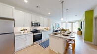 Located at 4150 Yeager Rd in West Lafayette, Indiana, this one-bedroom, one-bathroom residence offers a well-designed single-floor layout that makes efficient use of its space. The open-concept kitchen and living area serves as the heart of the home, where light wood-style flooring flows throughout. The kitchen is outfitted with white shaker cabinetry, granite countertops, stainless steel appliances including a refrigerator, range, and built-in microwave, and a central island with seating — ideal for casual dining or entertaining. Pendant lighting adds a warm, modern touch overhead. The living room is bright and inviting, featuring large windows with views of the surrounding greenery, and an accent wall that adds a pop of color and character to the space. An in-unit washer and dryer adds everyday convenience. The bedroom is comfortably sized, with plush carpet flooring, a ceiling fan, and a window that invites natural light. The bathroom features a clean, modern design with white cabinetry, a granite-topped vanity, wood-look flooring, and a well-lit mirror. A dedicated closet provides additional storage. The overall ambiance is fresh, contemporary, and move-in ready.