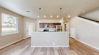 Located at 2631 Sunnyridge Rd in Nampa, Idaho, this two-story home offers a well-designed layout that balances functionality and comfort across both levels. The main floor centers around an open-concept living and kitchen area finished with light wood-look flooring that creates a clean, cohesive look throughout. The kitchen is a standout feature, equipped with a full suite of stainless steel appliances — including a refrigerator, electric range, and built-in microwave — rich dark cabinetry, light quartz countertops, and a large peninsula island illuminated by elegant pendant lighting. This space flows naturally into the dining and living areas, which are brightened by multiple windows that invite natural light. A dedicated laundry area is conveniently located on the main level as well. Upstairs, the bedrooms are carpeted for comfort and feature windows overlooking the surrounding neighborhood. The bathrooms are finished consistently with the rest of the home, showcasing dark wood vanities, light countertops, wood-look flooring, and a tub-shower combination. The overall aesthetic throughout is modern and neutral, with warm beige tones, white trim, and clean finishes that lend the home a fresh, move-in-ready feel.
