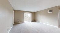 Located at 1486 Broadway in Chula Vista, CA, this two-bedroom, one-bathroom residence offers a practical single-floor layout with a well-organized flow between living spaces. The open living room is finished with plush carpet and neutral warm-toned walls, featuring a wall-mounted HVAC unit and a textured ceiling. A sliding glass door connects the living area to a private balcony, allowing natural light to fill the space and providing views of the surrounding neighborhood.

The kitchen is efficiently designed with white cabinetry, a black electric range, a stainless steel refrigerator, and a ceiling fan overhead. Light wood-look flooring runs through the kitchen area, complementing the clean, white finish of the cabinets and countertops.

Both bedrooms feature soft carpeting and warm neutral walls. The primary bedroom is a comfortable size with a dedicated closet, while the second bedroom also includes closet access. In total, the home offers three closets, providing ample storage throughout. The bathroom is clean and straightforward, equipped with a full tub-shower combination, wood-look flooring, and a white vanity. The overall aesthetic is consistent and neutral, making the space move-in ready and highly adaptable.