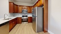 Located at 546 Plano Rd in Bowling Green, Kentucky, this single-floor residence offers a clean, neutral aesthetic throughout with a practical and well-organized layout. The kitchen is a standout feature, showcasing rich warm-toned wood cabinetry, stainless steel appliances including a refrigerator, range, and over-the-range microwave, light stone countertops, and durable hardwood-style flooring. The main living area benefits from crown molding, a ceiling fan, and a glass-paneled door that invites natural light and provides access to an outdoor balcony area. Adjacent to the living space is a dedicated laundry area, conveniently housing a full-size washer and dryer. The bedrooms are carpeted and finished with soft neutral walls, ceiling fans, and natural light from windows fitted with blinds. Storage is well-considered, with bedrooms offering both standard closets and a spacious walk-in closet equipped with wire shelving systems. The bathrooms are finished with rich wood vanities, light quartz-style countertops, undermount sinks with brushed nickel fixtures, and hardwood-style flooring, with one bathroom featuring a stylish round mirror. The overall ambiance is clean, move-in ready, and cohesive throughout.