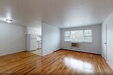 Located at 130 New Road in Parsippany-Troy Hills, NJ, this two-story, one-bedroom, one-bathroom unit offers a practical and comfortable layout spread across two levels. The main living area occupies the upper floor, where warm-toned hardwood floors run throughout the living room, hallway, and spacious primary bedroom, creating a cohesive and inviting atmosphere. The living room provides a generous open area filled with natural light, while the bedroom features a wide triple-pane window overlooking greenery outdoors, a wall-unit air conditioner, and baseboard heating. A staircase with wooden treads and a metal railing connects the entry level to the main floor, adding a classic architectural touch. The kitchen is outfitted with white cabinetry, dark countertops, a gas range, refrigerator, and a window above the sink, all set on clean tile flooring. The full bathroom is finished with neutral tile walls and flooring, a tub-shower combination, a window for natural ventilation, and a white vanity. Four closets distributed throughout the unit provide exceptional storage flexibility. The clean, neutral color palette and consistent finishes throughout give the space a tidy, move-in-ready appeal.
