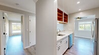 Located at 3135 Campus Dr in San Mateo, CA, this well-appointed 2-bedroom, 3-bathroom residence offers a thoughtfully designed single-level layout. Light-toned luxury vinyl plank flooring flows throughout, complemented by crown molding and recessed lighting that lend a clean, polished aesthetic.

The open living and dining area is bright and spacious, featuring large sliding glass doors that lead to a private balcony with views of surrounding greenery, and additional windows that fill the room with natural light. A ceiling fan adds comfort to the expansive living space.

The galley-style kitchen is efficiently laid out with white shaker cabinetry, quartz countertops, a stainless steel sink, and a full suite of stainless steel appliances including a refrigerator, range, and dishwasher. Warm wood open shelving provides a stylish accent. A convenient pass-through connects the kitchen to the living area.

The generously sized primary bedroom includes mirrored sliding closet doors, while the second bedroom features a large window with outdoor views and a baseboard heating system. Both rooms offer a calm, neutral palette.

The three bathrooms are finished with marble-look tile flooring. One features a glass-enclosed walk-in shower, while another includes a full tub and shower with decorative tile accents. Additional highlights include in-unit laundry and multiple closets for ample storage.