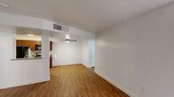 This single-floor residence offers a clean, functional layout designed for comfortable everyday living. Throughout the space, warm-toned hardwood-style flooring provides a cohesive and inviting foundation, complemented by crisp white walls and classic white baseboards.

The open living area flows seamlessly into the kitchen, separated by a structural beam that adds architectural definition. Ceiling fans in the living area ensure year-round comfort, while a centrally located HVAC vent supports efficient climate control. The kitchen is well-equipped, featuring rich medium-toned cabinetry, granite-look countertops, a stainless steel gas range, black refrigerator, built-in microwave, and a double-basin sink — providing ample workspace and storage for everyday cooking.

The two bedrooms are bright and airy, each receiving natural light through slatted blinds. One bedroom includes a sliding six-panel closet door that opens to a spacious reach-in closet with shelving, offering generous storage. Ceiling fans are present in the bedrooms as well, enhancing ventilation and comfort.

The bathrooms feature warm wood vanities topped with granite-style counters, large mirrors with overhead lighting, and bathtub/shower combinations. One bathroom includes a walk-in closet accessible directly from the room, adding a practical and desirable storage solution. The consistent use of hardwood-style flooring throughout ties the entire space together cohesively.