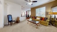 Located in Goodyear, AZ, this well-appointed 2-bedroom, 3-bathroom single-story home offers a thoughtfully designed layout that maximizes comfort and functionality. The open-concept living area features plush carpeting, crown molding, and a ceiling fan, with large windows that invite natural light and outdoor views. Adjacent to the living space, the combined kitchen and dining area is a standout, showcasing rich wood cabinetry, dark granite countertops, wood-look flooring, and black appliances including a refrigerator, range, and microwave. A convenient in-unit washer and dryer are tucked just off the kitchen. The spacious primary bedroom features soft carpet, a soothing accent wall, a ceiling fan, a large window, and an arched entry leading to a dedicated bathroom with a wood-toned vanity, granite countertop, and wood-look flooring. The second bedroom also offers comfortable carpeting, a ceiling fan, and natural light. The bathrooms are clean and modern, with one featuring a glass-enclosed shower and wood-look flooring. A hallway and closet round out the interior, ensuring ample storage throughout this well-designed Goodyear home.
