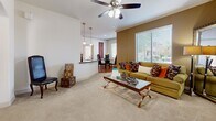 Located in Goodyear, AZ, this well-appointed 2-bedroom, 3-bathroom single-story home offers a thoughtfully designed layout that maximizes comfort and functionality. The open-concept living area features plush carpeting, crown molding, and a ceiling fan, with large windows that invite natural light and outdoor views. Adjacent to the living space, the combined kitchen and dining area is a standout, showcasing rich wood cabinetry, dark granite countertops, wood-look flooring, and black appliances including a refrigerator, range, and microwave. A convenient in-unit washer and dryer are tucked just off the kitchen. The spacious primary bedroom features soft carpet, a soothing accent wall, a ceiling fan, a large window, and an arched entry leading to a dedicated bathroom with a wood-toned vanity, granite countertop, and wood-look flooring. The second bedroom also offers comfortable carpeting, a ceiling fan, and natural light. The bathrooms are clean and modern, with one featuring a glass-enclosed shower and wood-look flooring. A hallway and closet round out the interior, ensuring ample storage throughout this well-designed Goodyear home.