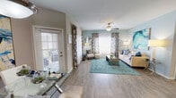 This single-story residence offers a thoughtfully designed open floor plan with wood-look flooring flowing consistently throughout. The entry leads into a central hallway connecting the main living areas, where a graceful arched doorway frames the transition to the kitchen. The kitchen is equipped with stainless steel appliances, including a refrigerator and dishwasher, dark granite-style countertops, white cabinetry, and a breakfast bar that opens toward the dining area. A dedicated laundry area accommodates a full-sized washer and dryer with overhead wire shelving for additional storage.

The living room is generously proportioned, featuring a ceiling fan, neutral walls, and multiple windows that allow natural light to fill the space. A sliding glass door provides direct outdoor access. The dining area is positioned adjacent to the living room, anchored by a pendant light fixture above.

The bedroom features a ceiling fan, a window with outdoor views, and access to a spacious walk-in closet outfitted with wire shelving and hanging rods. Two bathrooms are present, each featuring a tub-shower combination, wood-look flooring, and vanity with storage. The overall ambiance is bright, cohesive, and functionally arranged.