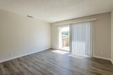 This single-floor unit offers a clean, functional layout designed for comfortable everyday living. The living area is a highlight of the space, featuring light gray vinyl plank flooring and a textured ceiling that adds character. A large sliding glass door floods the room with natural light and provides direct access to a private balcony, offering outdoor views of surrounding greenery and neighboring structures. Vertical blinds offer adjustable privacy and light control.

The kitchen is efficiently arranged with white shaker-style cabinetry, neutral countertops, and stainless steel appliances including a refrigerator, range, and dishwasher. Light wood-look flooring completes the clean, modern aesthetic.

The bedroom is a comfortable retreat with plush carpeting, a generously sized window with horizontal blinds, and neutral wall tones that create a calm atmosphere. A ceiling fan is installed in an additional room, enhancing airflow and comfort.

Two bathrooms serve the unit, each featuring white vanity cabinetry, modern brushed nickel hardware, and mirrors. One bathroom includes a stand-up shower, while the other features a medicine cabinet above the vanity. Both bathrooms are finished with wood-look flooring for a cohesive look throughout the unit.