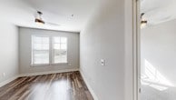 This single-floor residence in Mansfield, TX offers a clean, contemporary design throughout its thoughtfully laid-out spaces. The open living and kitchen area is anchored by rich wood-look flooring that extends seamlessly from room to room, creating a cohesive and inviting atmosphere. The kitchen is a functional centerpiece, featuring dark espresso cabinetry that reaches toward the ceiling, granite countertops, a full suite of stainless steel appliances including a refrigerator, range, microwave, and dishwasher, and recessed lighting that keeps the space bright and modern. A stainless steel utility island provides additional workspace and flexibility.

The living area flows naturally from the kitchen, bathed in natural light from windows fitted with horizontal blinds, and is complemented by a ceiling fan overhead. The bedrooms continue the light and airy aesthetic, with one featuring warm carpet flooring and another with the same wood-look planks found throughout the main living spaces. Each bedroom benefits from natural light through window pairs and ceiling fans for year-round comfort.

The bathroom is well-appointed with dark wood vanity cabinetry, granite countertops, a undermount sink, wall sconce lighting, and a tiled shower and tub combination. Wood-look tile flooring ties the bathroom's design into the broader aesthetic of the home, resulting in a cohesive, polished finish throughout.