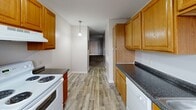 Located at 2725 S Emporia St in Wichita, Kansas, this two-bedroom, two-bathroom unit offers a well-organized single-level layout designed for comfortable everyday living. The kitchen serves as a functional hub, featuring warm honey-toned wood cabinetry, dark granite-style countertops, light wood-look vinyl plank flooring, a white appliance suite including a range and refrigerator, and a window that brings in natural light. A pendant light fixture adds a subtle design touch, while the galley-style configuration maximizes storage and workspace efficiency. Both bedrooms are carpeted in neutral beige tones, lending a cozy feel underfoot. The primary bedroom includes a double-panel closet with sliding doors, offering generous storage. Each bedroom features a window with blinds, allowing for natural light and outside views. The textured ceilings are consistent throughout the unit, complementing the clean, neutral wall tones. Both bathrooms are equipped with full tub and shower combinations finished in crisp white surrounds with chrome fixtures. A hallway connects the main living areas, and a dedicated closet provides additional storage. The overall ambiance is clean, neutral, and move-in ready.