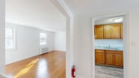Located at 90 Marilyn Place in Clifton, NJ, this 2-bedroom, 1-bathroom residence offers a well-organized layout across a single floor, accessible via a staircase entry. The interior is characterized by warm, polished hardwood floors that run throughout the main living areas and bedrooms, creating a cohesive and inviting ambiance.

The combined dining and living room is a bright, open space anchored by large windows that allow generous natural light to fill the room. A classic white radiator provides efficient heating, adding to the room's traditional charm. The space flows naturally through an arched opening into the adjacent areas of the home.

The kitchen features warm-toned wood cabinetry, granite-style countertops, a stainless steel sink, and white appliances including a gas range and overhead microwave. A subway tile backsplash and a window above the counter add both style and functionality.

Both bedrooms are well-proportioned and bright, each offering multiple windows with views of the surrounding neighborhood, classic radiator heating, and access to ample closet storage — with four closets distributed throughout the unit.

The bathroom is finished in crisp white with a tub-shower combination, a window for natural ventilation, a vanity with storage, and a wall mirror. A hallway connects the rooms efficiently, completing this clean and functional floor plan.