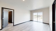 Located at 100 E National Ave in Milwaukee's vibrant Walker's Point neighborhood, this modern 1-bedroom, 2-bathroom unit offers a well-designed, contemporary living space across a single floor. Light gray wood-look flooring flows throughout, complemented by crisp white walls and dark baseboards that create a clean, modern aesthetic.

The open-concept kitchen is a standout feature, offering light maple cabinetry, dark countertops, stainless steel appliances including a refrigerator, range, and dishwasher, and a central island with pendant lighting — ideal for both cooking and entertaining. The kitchen connects seamlessly to the main living area, which is bathed in natural light from large sliding glass doors that open to a private balcony overlooking the Milwaukee cityscape.

The bedroom is a comfortable, well-proportioned space featuring a large window with expansive city views, ample natural light, and a dedicated closet. Both bathrooms are finished with light wood vanities, dark hardware, white countertops, and neutral stone-look tile flooring, lending a clean and contemporary feel. Dark-finish interior doors add a bold design contrast throughout. The overall ambiance is bright, modern, and move-in ready.