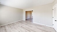 Located at 704 Windy Hill Circle in Fayetteville, NC, this two-story home offers four bedrooms and two bathrooms across a thoughtfully arranged layout. The main floor features a living room with vertical shiplap-style wall paneling, light luxury vinyl plank flooring, and dual windows that allow generous natural light to fill the space. The kitchen is well-appointed with white shaker cabinetry, a subway tile backsplash, marble-look countertops, black appliances including an electric range and over-the-range microwave, and a stainless steel sink with a matte black faucet. A partial dividing wall separates the kitchen from the main living area, adding architectural definition. The bathrooms feature white vanities with undermount sinks, matte black fixtures, and framed mirrors, alongside a clean white tub-shower surround with built-in shelving and matte black hardware. The bedrooms are carpeted with neutral tones and each includes a ceiling fan with light. The primary bedroom features a window with outdoor views. Textured ceilings are found throughout, lending a classic character to the home. The two floors offer a balanced distribution of living space, making this home a practical and comfortable residence.