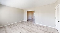 Located at 704 Windy Hill Circle in Fayetteville, NC, this two-story home offers four bedrooms and two bathrooms across a thoughtfully arranged layout. The main floor features a living room with vertical shiplap-style wall paneling, light luxury vinyl plank flooring, and dual windows that allow generous natural light to fill the space. The kitchen is well-appointed with white shaker cabinetry, a subway tile backsplash, marble-look countertops, black appliances including an electric range and over-the-range microwave, and a stainless steel sink with a matte black faucet. A partial dividing wall separates the kitchen from the main living area, adding architectural definition. The bathrooms feature white vanities with undermount sinks, matte black fixtures, and framed mirrors, alongside a clean white tub-shower surround with built-in shelving and matte black hardware. The bedrooms are carpeted with neutral tones and each includes a ceiling fan with light. The primary bedroom features a window with outdoor views. Textured ceilings are found throughout, lending a classic character to the home. The two floors offer a balanced distribution of living space, making this home a practical and comfortable residence.
