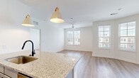 Located in Jacksonville, FL, this well-appointed 2-bedroom, 2-bathroom residence offers a thoughtfully designed single-floor layout with a clean, contemporary aesthetic throughout. The open-concept kitchen and living area serves as the heart of the home, featuring light wood-look flooring, a granite-topped island with an undermount sink and stylish pendant lighting, and gray shaker-style cabinetry paired with stainless steel appliances. The living area extends naturally from the kitchen, bathed in natural light from multiple windows and finished with a ceiling fan. A door provides direct access to an outdoor space, further enhancing the bright, airy atmosphere. Both bedrooms are carpeted for comfort and include ceiling fans and windows with exterior views. The generously sized primary bedroom benefits from its own dedicated closet with wire shelving systems offering excellent organizational capacity. The two bathrooms are finished with granite vanity countertops, wood-look flooring, and oil-rubbed bronze fixtures, with one featuring a tiled tub-shower combination. A dedicated in-unit laundry area with a full-size washer and dryer adds everyday convenience. Two closets throughout the home provide ample storage for residents.