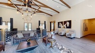 Located at 4565 N Garland Ave in Garland, TX, this one-bedroom, one-bathroom residence offers a smartly designed single-floor layout that maximizes every square foot. The open-concept kitchen and living area serves as the heart of the home, anchored by a granite-topped island with bar seating and elegant glass pendant lighting overhead. The kitchen is equipped with stainless steel appliances, including a French door refrigerator, microwave, and range, complemented by two-tone cabinetry — warm wood upper cabinets paired with crisp white lower cabinets — and a striking cobalt blue hexagonal tile backsplash that adds a bold design accent. Rich wood-style flooring flows throughout the main living areas. The living room offers a bright, inviting atmosphere with natural light streaming through a window with blinds and curtains, alongside a decorative wall arrangement of teardrop-shaped mirrors that adds visual depth. The bedroom features plush carpeting, a large window with outdoor views, and direct access to the bathroom and a dedicated closet. The bathroom includes a vanity with granite countertops and framed mirror. A hallway connects the private spaces cleanly, finishing this efficient and stylish residence with a cohesive, contemporary aesthetic.
