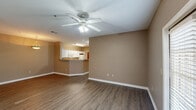 This single-story residence in Baton Rouge, Louisiana offers a functional and cohesive layout across two bedrooms and two full bathrooms. The open-concept living area serves as the central hub of the home, featuring durable wood-style flooring, neutral taupe walls, and a ceiling fan with light fixture overhead. The space flows directly into the dining area, which connects to the kitchen via a peninsula counter with a granite-style surface — a practical feature that enhances both the visual openness and usability of the shared living space.

The kitchen is well-appointed with white cabinetry extending to the ceiling for ample storage, granite-style countertops, a stainless sink, and white appliances including a range and built-in microwave. A hallway connects the main living area to the private quarters, where both bedrooms feature neutral carpet flooring. The primary bedroom is generously sized, equipped with a ceiling fan and a walk-in closet with built-in shelving. The second bedroom also features soft carpet and shares a similarly understated aesthetic.

Each bathroom includes a white vanity with granite-style countertops, a large mirror, and a shower/tub combination. Wood-style flooring carries through the hallways and wet areas, contributing to a consistent, clean finish throughout the residence.