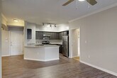 Located at 701 Highland Ave NE in Atlanta's vibrant Old Fourth Ward neighborhood, this well-appointed single-floor residence offers two bedrooms, two bathrooms, and a thoughtfully designed layout. The open-concept living and kitchen area serves as the heart of the home, featuring rich hardwood-style flooring, crown molding, and a decorative arched column that adds architectural character. The kitchen is equipped with dark cabinetry, granite countertops, a full suite of stainless steel appliances including a range, microwave, and refrigerator, and a peninsula with an integrated sink — ideal for both cooking and casual dining. Track lighting overhead ensures ample illumination throughout. The spacious living room benefits from multiple windows that invite natural light and provide outdoor views, complemented by a ceiling fan for year-round comfort. The primary bedroom offers generous proportions with plush carpeting and is accompanied by a walk-in closet featuring built-in wire shelving. The second bedroom is equally comfortable with neutral tones and carpet flooring. Both bathrooms are finished with granite-topped vanities and tiled tub-shower combinations. Three hallways connect the space efficiently, and two closets provide ample storage throughout.