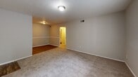 Located at 204 Glenwood Rd in Greenville, SC, this single-floor, one-bedroom, one-bathroom residence offers a well-organized and efficient layout. The living room features a textured ceiling, neutral gray walls, and a mix of hardwood-style and plush carpet flooring, creating a comfortable and welcoming atmosphere. Natural light filters in through window blinds, adding brightness to the space. The kitchen is equipped with white cabinetry accented by black hardware, speckled granite-style countertops, a stainless steel sink, a dishwasher, and a full-size refrigerator, all set atop light wood-style flooring. The bedroom is a generously sized retreat with soft carpet, a ceiling fan with light fixture, a window with blinds offering outdoor views, and access to a dedicated walk-in closet with built-in shelving. Two additional closets provide ample storage throughout the unit. The bathroom features a white vanity with speckled countertop, a large mirror, and hardwood-style flooring. A connecting hallway ties the rooms together seamlessly. With three closets total, this residence prioritizes practical storage alongside comfortable living.
