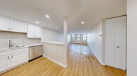 Located at 967 Asylum Ave in Hartford, CT, this thoughtfully renovated single-floor unit offers a clean, modern aesthetic with consistent light wood flooring flowing throughout every room. The open-concept layout connects the kitchen directly to the living area, creating a seamless, airy feel. The kitchen is well-appointed with white shaker cabinetry, a classic subway tile backsplash, stainless steel appliances including a refrigerator, gas range, microwave, and dishwasher, and a built-in breakfast bar that provides additional seating and counter space. Recessed lighting illuminates both the kitchen and living area, enhancing the bright, contemporary atmosphere. The spacious living area benefits from large windows fitted with blinds, allowing for generous natural light and views of the surrounding greenery. The bedroom spaces are generously proportioned, each featuring the same warm wood flooring, neutral wall tones, recessed lighting, and large windows that fill the rooms with daylight. The bathroom is finished with large-format tile flooring, a white vanity with brushed nickel fixtures, and a full tub and shower surrounded by crisp white subway tile. Throughout the unit, clean white walls, modern trim, and a cohesive design palette contribute to a polished, move-in-ready living environment.