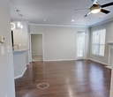 Unit #1407 at Bell Starwood in Frisco, Texas is a well-appointed 3-bedroom, 3-bathroom apartment spanning 910 square feet on a single floor. The inviting living room features rich hardwood-style flooring, crown molding, a classic white-mantled fireplace, a ceiling fan, and multiple windows that fill the space with natural light. The kitchen is equipped with dark espresso cabinetry, granite countertops, a subway tile backsplash, and stainless steel appliances including a refrigerator and dishwasher. Each of the three bedrooms offers ceiling fans and crown molding, with select rooms featuring plush carpet flooring. The primary bedroom measures 140 square feet and includes direct access to a private bathroom and a dedicated closet. The bathrooms are finished with dark vanity cabinetry, granite countertops, large mirrors, and tub-shower combinations with white tile surrounds set atop hardwood-style flooring. A spacious walk-in closet with wire shelving provides ample storage. The in-unit laundry room houses a full-size washer and dryer alongside the water heater. Crown molding and consistent finishes throughout the unit contribute to a cohesive and polished aesthetic.