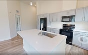 This 850-square-foot, single-floor unit at 1224 E Brookland Park Blvd in Richmond, Virginia offers a clean, modern aesthetic across 2 bedrooms, 2 bathrooms, a kitchen, and a closet. Consistent light-tone wood-look flooring and crisp white walls flow throughout, creating a bright and cohesive interior. Soaring ceilings amplify the sense of space in every room.

The kitchen is a standout feature, boasting tall gray shaker-style cabinetry, black appliances including a refrigerator, range, and microwave, a white countertop island with an integrated sink, and pendant lighting that highlights the impressive ceiling height. A window provides natural light and outdoor views.

Both bedrooms are generously proportioned with high ceilings and large windows that invite abundant natural light. The primary bedroom measures 160 square feet, offering a comfortable retreat. The second bedroom similarly benefits from dual windows with outdoor views.

Each of the two bathrooms features a tub-shower combination, a vanity with white countertops, and matching wood-look tile flooring. Two-panel interior doors with brushed nickel hardware are found throughout the unit, lending a polished, uniform finish. The overall ambiance is clean, contemporary, and move-in ready.