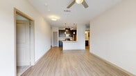 Located at 202 East Ufer Street in Fredericksburg, TX, this single-floor, 2-bedroom, 2-bathroom residence offers a thoughtfully designed open-concept layout. The combined kitchen and living area serves as the heart of the home, featuring light wood-style flooring, a ceiling fan, and seamless flow between spaces. The kitchen is a standout, equipped with dark espresso cabinetry, stainless steel appliances including a range, microwave, and refrigerator, and a peninsula island topped with a granite-look countertop and an undermount sink — ideal for both meal prep and casual dining.

Both bedrooms are carpeted for comfort, each outfitted with a ceiling fan and windows that allow natural light and outdoor views. The primary bedroom includes a dedicated closet with wire shelving for organized storage. Both bathrooms mirror each other in design, featuring dark cabinetry with brushed nickel hardware, a quartz-style vanity countertop, and a tub/shower combination with elegant marble-look tile surround and a curved curtain rod. A private balcony adds additional outdoor living space. The residence also includes two closets, providing ample storage throughout.
