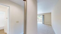 Located at 2366 American River Dr in Sacramento, CA, this one-bedroom, three-bathroom unit offers a well-organized single-floor layout designed for comfortable everyday living. The combined kitchen and living room area forms the heart of the space, where the kitchen features light wood cabinetry, speckled stone countertops, wood-look flooring, and white appliances including a range, over-the-range microwave, and refrigerator. A peninsula counter neatly separates the kitchen from the carpeted living area, which is filled with natural light and includes a ceiling fan. Sliding glass doors open to a private balcony overlooking lush greenery, bringing the outdoors in. The bedroom is a well-proportioned retreat with plush carpet, neutral walls, and a window framing peaceful outdoor views. The three bathrooms are finished consistently with light wood vanities, speckled stone countertops, large mirrors, and wood-look flooring. At least one bathroom includes a full tub and shower combination with clean white surround. Throughout the unit, warm beige tones, white trim, and abundant natural light create a bright, cohesive ambiance that feels open and inviting.