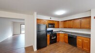Located at 1 Reler Lane in Somerset, NJ, this one-bedroom, one-bathroom residence offers a well-organized single-floor layout designed for comfortable everyday living. Rich hardwood-style flooring flows consistently throughout the unit, lending warmth and visual continuity to every room.

The open-concept layout connects the kitchen and living areas seamlessly. The kitchen is outfitted with warm honey-toned cabinetry offering generous storage, dark granite-style countertops, and a full suite of black appliances including a gas range, built-in microwave, dishwasher, and refrigerator. The adjacent living area is bright and spacious, featuring neutral white walls and a large sliding glass door that invites natural light and provides views of the surrounding outdoor greenery.

A second living area extends the functional space further, offering flexibility for a dining setup, home office, or additional lounge area. The bedroom is a comfortable, well-proportioned retreat with natural light from a window with blinds and a closet with built-in shelving for organized storage.

The bathroom features a full tub-shower combination with clean white tile work accented by a decorative tan mosaic pattern, adding a subtle design touch. Throughout the unit, the clean, neutral palette and consistent flooring create a cohesive and move-in-ready living environment.