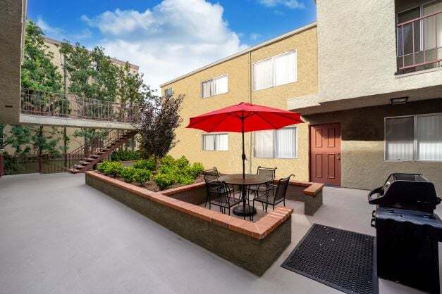 El patio con máquina de barbacoa y asientos de patio en Ridgeview Apartments en Northridge - The Ridgeview