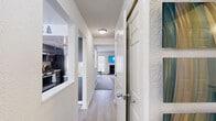 This multi-level home in Ann Arbor, Michigan, offers 2 bedrooms and 4 bathrooms spread across three floors, providing a well-organized and functional layout. The entry hallway features light wood-style flooring that flows through the main living areas, creating a cohesive and welcoming feel throughout.

The main living room showcases a fireplace, carpeted flooring, and natural light from windows and a glass door, with an accent wall in a bold teal blue. A second living area features warm yellow walls, another fireplace, and access to a patio. The dedicated dining room is bright and airy, with large windows and a door leading outside.

The kitchen is a standout feature, designed in a galley style with sleek dark cabinetry, white quartz countertops, stainless steel appliances including a gas range, and light hardwood-style flooring. A second kitchen space adds versatility to this home.

The two bedrooms are carpeted and well-proportioned, with the primary bedroom offering generous space. The four bathrooms are clean and modern, featuring floating dark vanities with white countertops, light wood-style flooring, and tasteful finishes.

A utility room, multiple staircases, and a hallway contribute to the home's practical and efficient design throughout all three levels.