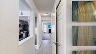 This multi-level home in Ann Arbor, Michigan, offers 2 bedrooms and 4 bathrooms spread across three floors, providing a well-organized and functional layout. The entry hallway features light wood-style flooring that flows through the main living areas, creating a cohesive and welcoming feel throughout.

The main living room showcases a fireplace, carpeted flooring, and natural light from windows and a glass door, with an accent wall in a bold teal blue. A second living area features warm yellow walls, another fireplace, and access to a patio. The dedicated dining room is bright and airy, with large windows and a door leading outside.

The kitchen is a standout feature, designed in a galley style with sleek dark cabinetry, white quartz countertops, stainless steel appliances including a gas range, and light hardwood-style flooring. A second kitchen space adds versatility to this home.

The two bedrooms are carpeted and well-proportioned, with the primary bedroom offering generous space. The four bathrooms are clean and modern, featuring floating dark vanities with white countertops, light wood-style flooring, and tasteful finishes.

A utility room, multiple staircases, and a hallway contribute to the home's practical and efficient design throughout all three levels.