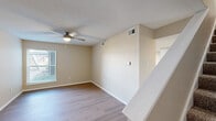This two-story home in Memphis, TN offers a thoughtful layout spread across two floors, providing comfortable separation between living and sleeping areas. The main level features multiple living spaces with light wood-tone flooring that flows throughout, neutral warm-toned walls, and textured ceilings. Ceiling fans with integrated lighting are installed in key rooms, enhancing airflow and comfort. The kitchen is a standout feature, equipped with crisp white shaker-style cabinetry, granite-look countertops, a classic subway tile backsplash, and a full suite of stainless steel appliances including a refrigerator, range, microwave, and dishwasher. A skylight adds bright, natural illumination to the kitchen area. The three bedrooms are well-sized, with the generously proportioned primary bedroom offering dedicated closet space. Bedrooms feature plush carpeting, while living areas and the kitchen showcase easy-maintenance hard-surface flooring. The 2.5 bathrooms are clean and functional, each featuring tub/shower combinations with built-in shelving and granite-accented vanities with brushed nickel hardware. A staircase connects the two floors, with hallways and closets providing practical storage throughout. Natural light filters in through multiple windows across the home.