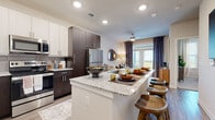 This thoughtfully designed single-floor residence offers a cohesive blend of modern style and everyday functionality. The kitchen is a standout feature, showcasing two-tone cabinetry with dark espresso lower cabinets and crisp white upper cabinets, granite countertops, a subway tile backsplash, and a full suite of stainless steel appliances. A large island with seating provides both additional prep space and a casual dining option. The kitchen flows seamlessly into the open living area, which is finished with wood-look plank flooring and receives generous natural light through glass doors that open to an outdoor balcony. A ceiling fan adds to the comfort of the space. The bedroom is a calm retreat, featuring plush carpet, multiple windows dressed with blinds and sheer curtains, and a ceiling fan overhead. The bathroom is generously proportioned, with dark cabinetry, dual granite-topped vanities, a large mirror, a tub and shower combination with marble-style tile surround, and wood-look flooring that ties the space together. Throughout the residence, a neutral color palette, recessed lighting, and consistent high-quality finishes create a polished and inviting atmosphere.