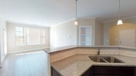 This single-story residence on Warrick Trail offers a thoughtfully designed open-concept floor plan that promotes seamless flow between living spaces. The kitchen serves as a central highlight, outfitted with rich dark-espresso cabinetry, granite countertops, a classic white subway tile backsplash, and a full suite of stainless steel appliances including a range, microwave, dishwasher, and refrigerator. Pendant lighting illuminates the granite-topped peninsula, which opens directly to the living and dining areas—an ideal layout for everyday functionality. Crown molding accents the main living areas, which feature light hardwood-style flooring that extends throughout the common spaces, while built-in shelving adds a decorative touch near the entryway arch. The bedrooms are carpeted for comfort, each equipped with ceiling fans and natural light supplied by blinds-fitted windows. The bathroom features a dark vanity with granite countertop, a large mirror, and wood-look flooring. A half bath with an exterior-facing window provides added convenience. The overall palette of warm neutral tones creates a clean, cohesive ambiance throughout the home.