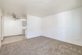 Located at 1917 F Avenue in National City, California, this single-floor, one-bedroom, one-bathroom unit offers an efficient and thoughtfully arranged layout. The living area features neutral-toned carpet and clean white walls, with a ceiling fan providing year-round comfort. A window fitted with vertical blinds allows natural light to brighten the space. The galley-style kitchen is well-appointed with gray shaker cabinetry, marble-look countertops, a stainless steel sink, and white appliances including a refrigerator, electric range, and over-range microwave hood. Light wood-look flooring runs throughout the kitchen, adding warmth and easy maintenance. Notably, the kitchen also accommodates an in-unit washer and dryer, a practical convenience. The bedroom is generously proportioned for the overall footprint of the unit, complete with soft carpet, a window for natural light, and a sliding-door closet with a built-in hanging rod. The bathroom features a full tub-shower combo with white surround, light wood-look flooring, and a white vanity. A connecting hallway ties the rooms together for a cohesive flow. The unit's clean, move-in-ready condition and functional design make it a practical choice in the National City area.
