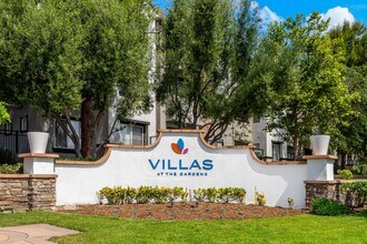 Welcoming Villas at the Gardens Signage Surrounded by Trees and Flowers - Villas at the Gardens