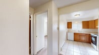 Located at 2026 Carlee Dr in Pueblo, Colorado, this two-bedroom, one-bathroom unit offers a practical and efficient single-floor layout. The interior features a textured ceiling throughout, lending a consistent character to each room. A central hallway connects the main areas, providing clear and logical flow between spaces.

The kitchen is well-appointed with warm-toned wood cabinetry offering ample storage, light countertops, a double-basin sink, a dishwasher, and an electric range. A window above the sink brings in natural light, and light-colored tile flooring ties the space together cleanly.

Both bedrooms are carpeted and bright, each featuring windows with horizontal blinds that allow for natural light and privacy. The primary bedroom is generously sized for the footprint of the home and includes a closet. Baseboard heating is present in the bedrooms, supplemented by a wall-mounted air conditioning unit in one room. The second bedroom also benefits from natural light with outdoor views.

The bathroom includes a single-sink vanity with under-cabinet storage, a toilet, and a tub-shower combination with a speckled surround, finished with tile flooring. The entry area features a solid exterior door and opens directly to the carpeted interior hallway, creating a straightforward and functional transition into the home.