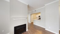 This single-floor residence offers a thoughtfully designed layout that balances comfort and functionality throughout. The living area serves as the heart of the home, showcasing warm hardwood flooring, crown molding, and a classic fireplace with a white mantel as a focal point. A ceiling fan overhead and multiple windows with blinds allow ample natural light to fill the space, creating a bright and welcoming atmosphere.

The kitchen is accessible via a pass-through counter that connects it seamlessly to the living area, promoting an open and social flow. White cabinetry, stainless steel appliances — including a refrigerator, range, and microwave — along with a dishwasher and light countertops give the kitchen a clean, modern feel.

A dedicated laundry area is conveniently located off the kitchen, housing a full-size washer and dryer alongside a water heater. The bathroom features a generously sized soaking tub and shower combination enclosed in classic white tile with a neutral accent border.

The bedroom is well-proportioned, finished with plush carpeting, a ceiling fan, and a window that invites natural light. A welcoming entryway with crown molding and clean white trim ties the entire space together, making this residence both practical and inviting.