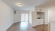Located at 20 Franklin Ln in Manalapan, NJ, this 3-bedroom, 2-bathroom single-floor home offers a clean, modern aesthetic throughout. The open-concept living room features light wood-style flooring, bright white walls, and a sliding glass door dressed with vertical blinds that floods the space with natural light and provides access to the outdoors. Adjacent to the living area, the kitchen is thoughtfully appointed with gray shaker-style cabinetry, light quartz countertops, stainless steel appliances including a refrigerator, gas range, and microwave, as well as a double undermount sink — all flowing seamlessly from a peninsula that defines the space. A dedicated laundry room houses a full-size side-by-side washer and dryer with overhead shelving for added storage. The primary bedroom offers plush carpeting, a bright window with neighborhood views, and direct access to an en-suite bathroom. The bathrooms are finished with marble-style tile flooring and a glass-enclosed walk-in shower. Additional bedrooms feature the same neutral palette and wood-style or carpeted flooring. A closet provides extra storage. The home's consistent use of light tones and modern finishes creates a cohesive, move-in-ready living environment.