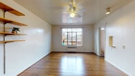 Located at 630 E. Town St. in Columbus, Ohio, this single-floor unit offers a straightforward and functional layout. The main living area is characterized by warm hardwood floors that run throughout, a ceiling fan with integrated lighting, and a window that frames views of the surrounding urban neighborhood while allowing natural light to fill the space. A wall-mounted shelving unit provides convenient storage and display options.

The entryway area features multiple wood-toned doors, including two closets that offer generous storage, making organization easy for residents. A charming built-in niche adds a subtle architectural detail to the wall.

Adjacent to the living area, the compact kitchen is equipped with rich, dark wood cabinetry, a white range, and under-cabinet lighting that brightens the workspace. The kitchen connects seamlessly to the rest of the unit through an open pass-through layout.

The bathroom is clean and functional, appointed with a pedestal sink, a lighted vanity mirror, and classic white fixtures throughout, maintaining a bright and tidy atmosphere.

Overall, the unit presents a practical and comfortable living space with classic character, hardwood floors as a unifying design element, and a compact, efficient layout well-suited to urban living in the heart of Columbus.