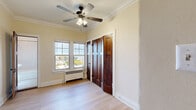 Located in Milwaukee, WI, this studio offers a thoughtfully utilized layout that maximizes every square foot. The main living area is bright and welcoming, featuring light hardwood-style flooring, warm cream-toned walls, and elegant crown molding that adds a classic architectural touch throughout. A ceiling fan with integrated lighting serves as a practical focal point overhead, while a radiator unit beneath the windows provides efficient heating.

Natural light flows in through multiple gridded windows, offering views of the surrounding neighborhood. Rich, dark-stained wood panel doors add a warm, vintage character that complements the building's traditional aesthetic. Three closets provide an impressive amount of storage for a studio of this size.

The kitchenette is neatly tucked into a dedicated alcove and includes white cabinetry, a granite-style countertop with an undermount sink, a compact gas range, and a full-size refrigerator — all the essentials for everyday cooking. The bathroom is efficiently designed, featuring a combination tub and shower with built-in shelving, a pedestal sink, and a toilet. The layout keeps all functions accessible while maintaining a clean, organized feel throughout the space.