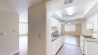 Located at 301 E Verdugo Ave in Burbank, California, this single-floor, 2-bedroom, 2-bathroom residence offers a well-organized layout with a bright and neutral aesthetic throughout. The open-concept kitchen flows directly into the dining and living areas, creating a connected and functional common space. The kitchen is outfitted with white cabinetry, grey countertops, a gas range, built-in microwave, and a stainless steel sink, all beneath a tray ceiling with recessed lighting. The adjacent living and dining area features light hardwood-style flooring, a ceiling fan, crown molding, and large windows dressed with vertical blinds that allow ample natural light. The primary bedroom is generously sized, complete with carpet flooring, a ceiling fan, and natural light from a large window. It is accompanied by a spacious walk-in closet with built-in shelving and dual hanging rods. The second bedroom offers light hardwood-style flooring, a tray ceiling detail, and a bright window. Both bathrooms are finished with tile flooring and white vanities; one includes a shower-tub combination with a sliding glass enclosure. Three hallways connect the rooms efficiently throughout the single-level floor plan, completing a cohesive and comfortable living environment.