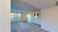 Located in Grandville, Michigan, this single-floor, 2-bedroom, 2-bathroom residence offers a well-organized layout designed for comfortable everyday living. The open-concept living room is generously sized, featuring soft wall-to-wall carpeting, a textured ceiling, and large vertical-blind windows alongside a sliding glass door that fills the space with natural light and provides outdoor access. A pass-through window connects the living area to the kitchen, creating a sense of openness between the two spaces. The galley-style kitchen is equipped with warm wood cabinetry, durable wood-look vinyl plank flooring, stainless steel appliances including a refrigerator, electric range, and microwave, as well as a double sink with ample counter space. The spacious primary bedroom features plush carpeting, a window overlooking the neighborhood, and a textured ceiling. The second bedroom is equally comfortable with soft carpeting and neutral tones throughout. Both bathrooms mirror the kitchen's warm wood cabinetry and vinyl plank flooring; one features a single vanity, while the other offers a full tub-shower combination. A hallway connects the private areas of the home, and a dedicated closet provides additional storage. The overall ambiance is clean, neutral, and move-in ready.