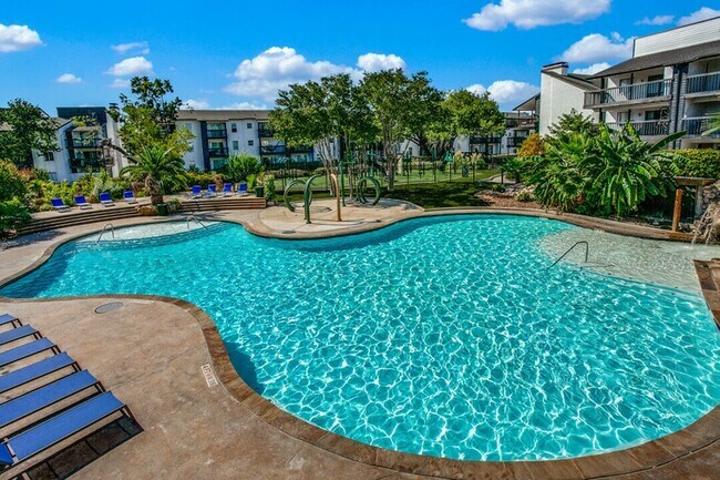 Una piscina resplandeciente de gran tamaño rodeada de un paisaje exuberante y vistas panorámicas. - Palatia Apartment Homes