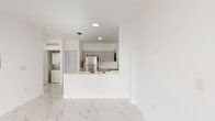 Located at 1435 W 29th St in Hialeah, FL, this well-designed one-bedroom, one-bathroom unit offers a clean, modern aesthetic throughout. Polished marble-look porcelain tile floors run continuously across the entire space, creating a bright and cohesive feel. The open-concept kitchen and living area forms the heart of the unit, with a peninsula counter separating the two zones. The kitchen is outfitted with taupe flat-front cabinetry extending to the ceiling, white quartz countertops, and a full suite of stainless steel appliances including a refrigerator, electric range, and over-the-range microwave. Recessed lighting illuminates the living area, which benefits from a clean, airy atmosphere. The bedroom is a comfortable, well-proportioned space with large sliding glass doors that open onto a private balcony, offering open views of the surrounding Hialeah neighborhood and abundant natural light. The bathroom features a tub-shower combination, a single-sink vanity with modern cabinetry, and consistent marble-look tile flooring. A dedicated laundry area with stacked washer and dryer units adds everyday convenience, while two closets and a utility room provide ample storage throughout the unit.