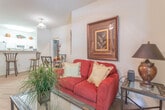 Located at 650 Stoney Creek Ln in Newport News, Virginia, this single-story residence offers a well-organized and functional layout across a comfortable footprint. The living room serves as the heart of the home, featuring carpet flooring, a ceiling fan, and a sliding glass door that fills the space with natural light and provides outdoor access. The galley-style kitchen is efficiently designed with white cabinetry, light countertops, tile flooring, and white appliances including a range, microwave, refrigerator, and dishwasher. The home includes multiple bedrooms, each carpeted and featuring windows that bring in natural light. The primary bedroom is notably spacious with vaulted ceilings and direct access to a private bathroom, while additional bedrooms offer generous proportions suitable for varied uses. Two full bathrooms are present in the home, each finished with tile flooring and a tub-shower combination. The overall interior palette is light and neutral, with warm-toned accent walls in select rooms adding visual interest. The consistent use of carpet in living and sleeping areas and tile in wet areas reflects a practical and clean design sensibility throughout the home.